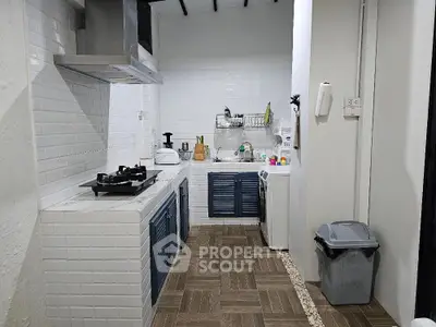 Modern kitchen with gas stove and washing machine in stylish apartment