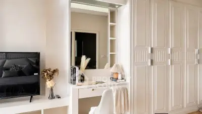 Elegant bedroom with built-in wardrobe and stylish vanity area, perfect for modern living.