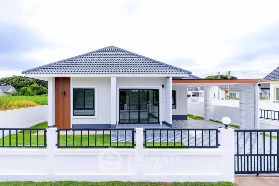 Charming modern single-story house with sleek design and spacious front yard.