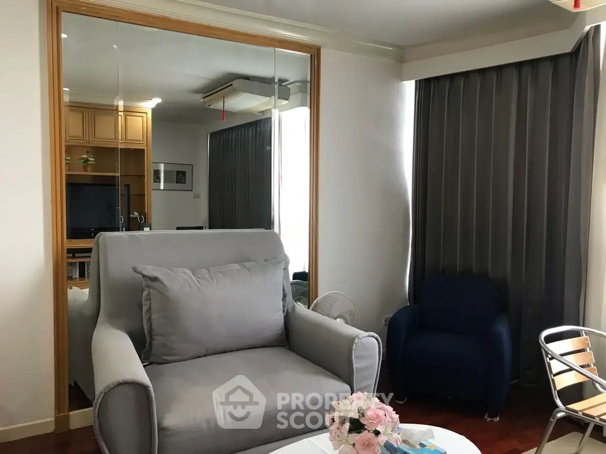 Cozy living room with modern furniture and large window, perfect for relaxation.