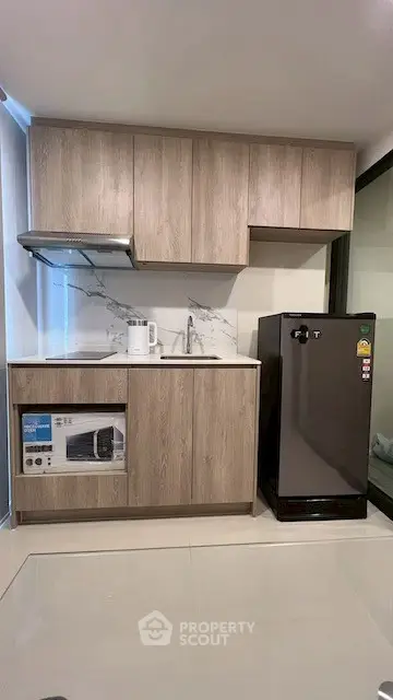 Modern kitchen with sleek cabinets and compact appliances in a stylish apartment.