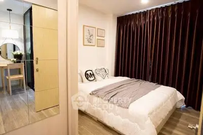 Cozy bedroom with modern decor and ample natural light, featuring elegant curtains and stylish furnishings.