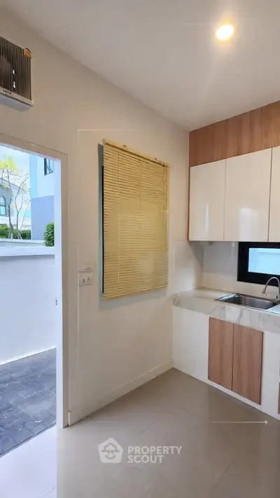 Modern kitchen with sleek cabinetry and outdoor access, perfect for culinary enthusiasts.
