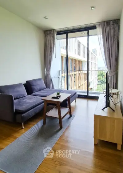 Modern living room with large windows and balcony view in a stylish apartment.