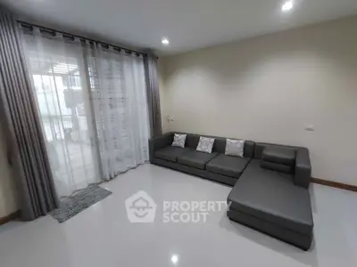 Spacious modern living room with sleek gray sectional sofa and large windows for natural light.