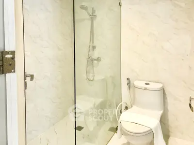 Modern bathroom with glass shower and sleek white fixtures