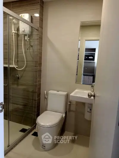 Modern bathroom with glass shower and sleek fixtures in a contemporary apartment.