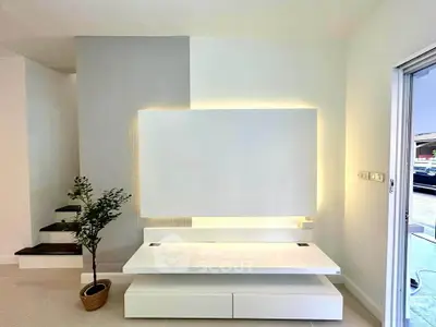 Modern minimalist living room with sleek white TV stand and ambient lighting