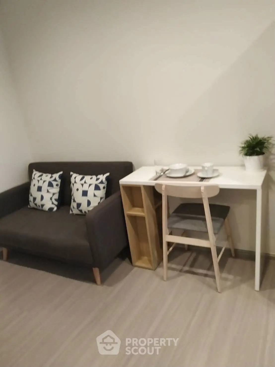 Cozy small living area with modern sofa and dining table in compact apartment.