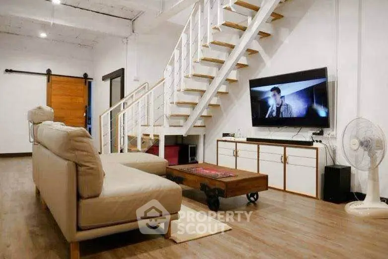 Stylish living room with modern staircase and cozy seating area
