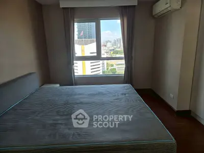 Spacious bedroom with city view and air conditioning in modern apartment.