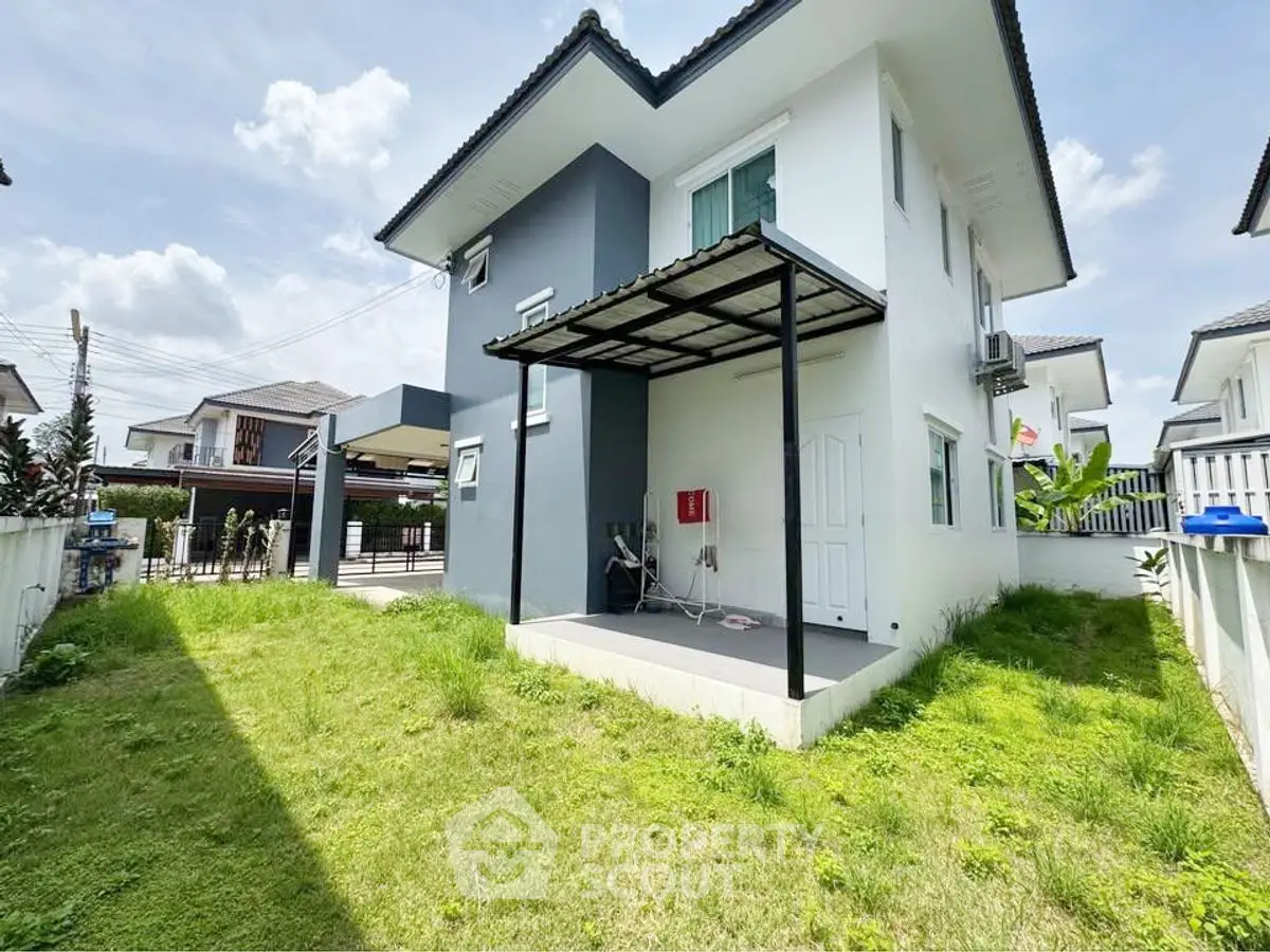 Charming two-story house with lush green garden and modern exterior design.