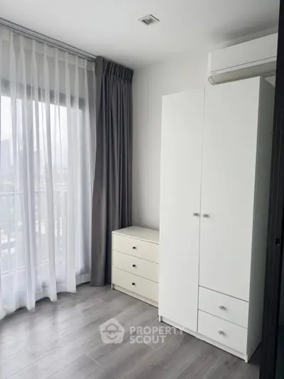 Modern bedroom with white wardrobe and city view from window