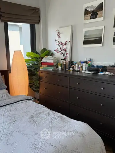 Cozy bedroom with elegant dresser and soft lighting, perfect for relaxation.