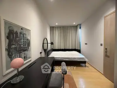 Modern bedroom with stylish decor and natural light, featuring a cozy bed and elegant furnishings.