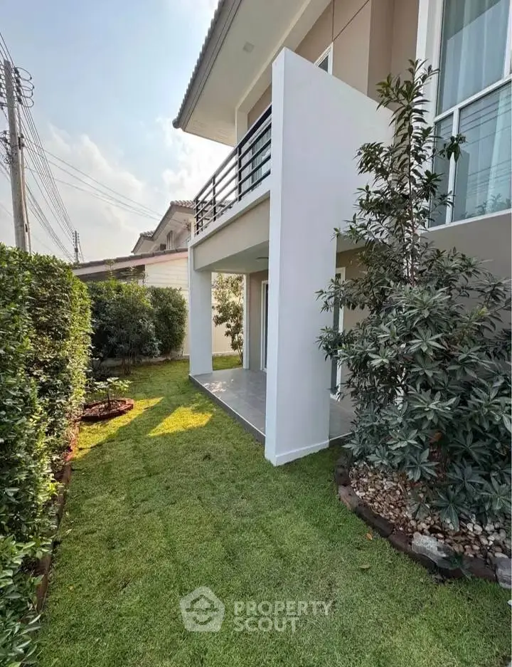 Charming modern house exterior with lush garden and balcony, perfect for family living.