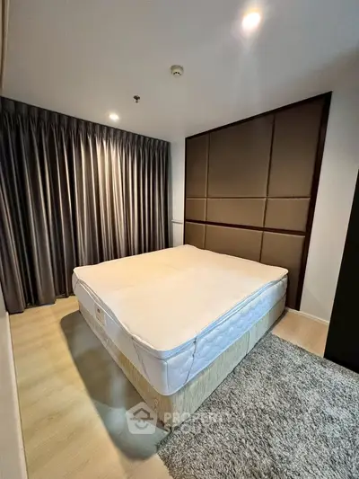 Spacious bedroom with modern decor and cozy lighting, featuring a comfortable bed and elegant curtains.