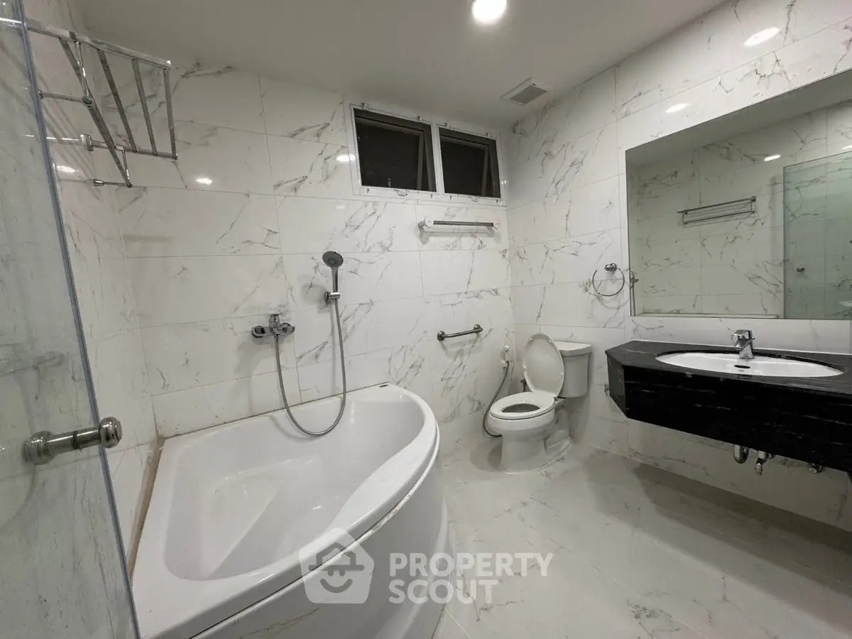 Luxurious marble bathroom with modern fixtures and spacious bathtub