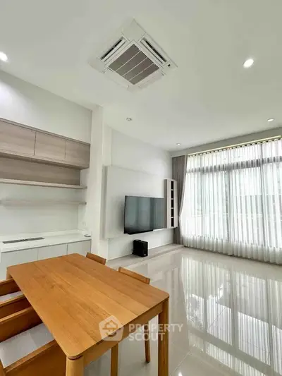 Modern living room with sleek furniture and large windows for natural light.