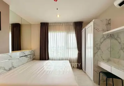 Modern bedroom with marble accents and large window offering natural light.