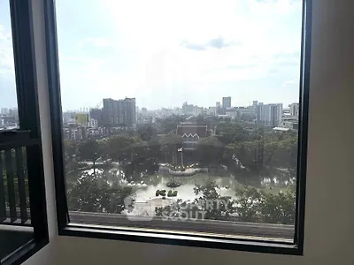 Stunning cityscape view from a high-rise window overlooking a serene park and urban skyline.