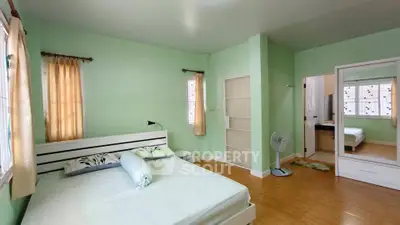 Spacious bedroom with mint green walls and natural light