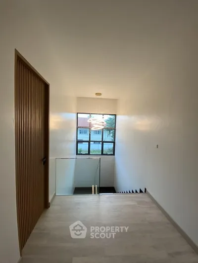 Modern hallway with large window and stylish lighting in contemporary home