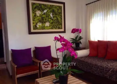 Charming living room with vibrant decor and elegant floral accents, perfect for cozy relaxation.