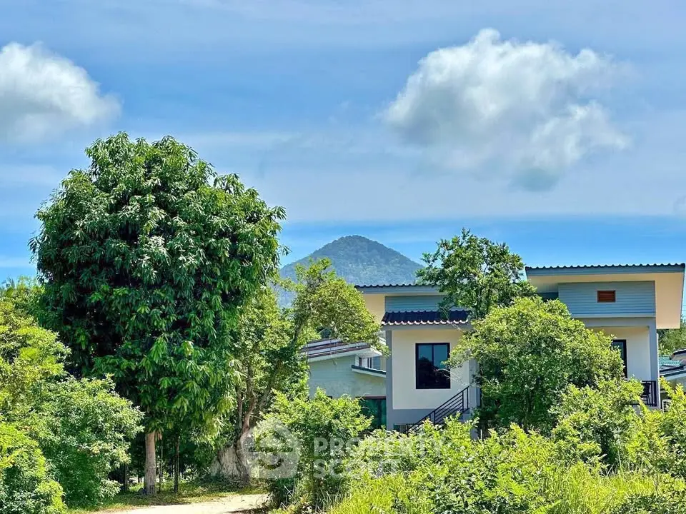 Charming modern home with lush greenery and scenic mountain backdrop, perfect for nature lovers.