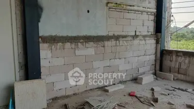 Under-construction building with exposed brick walls and construction materials.