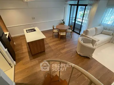 Modern open-plan living room with kitchen island and balcony view