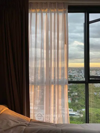 Stunning city view from a cozy bedroom window with soft curtains and warm lighting.