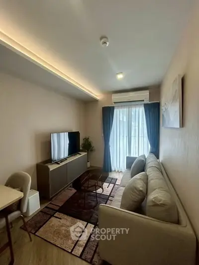 Modern living room with cozy sofa, stylish decor, and natural light from large window.