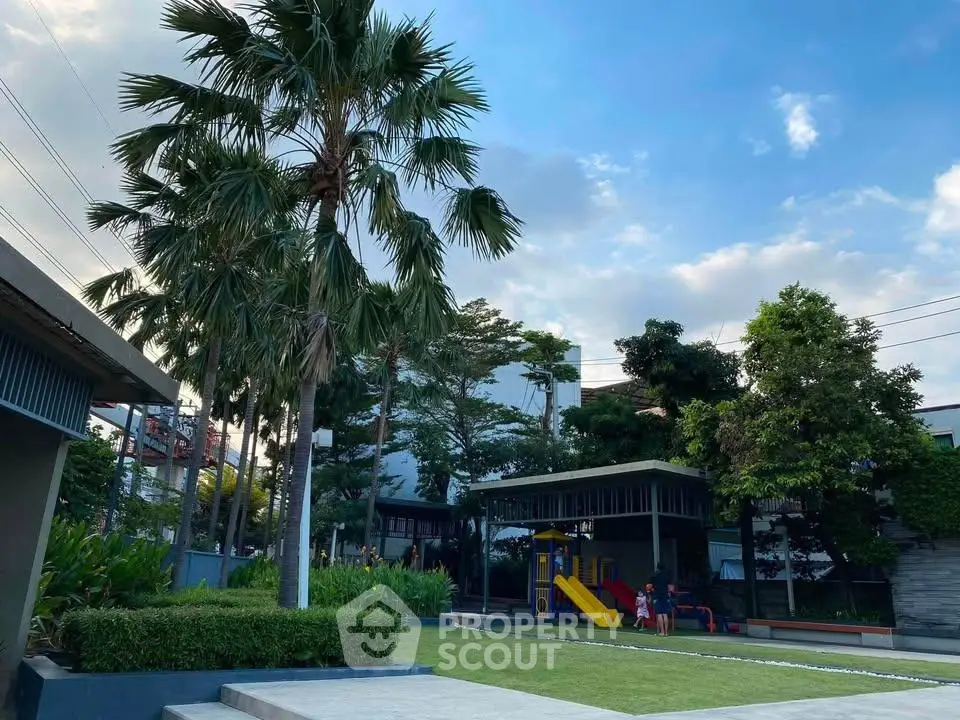 Beautiful outdoor garden area with playground and lush greenery in a residential complex.