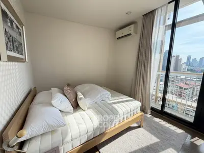 Bright bedroom with city view and balcony access in modern apartment