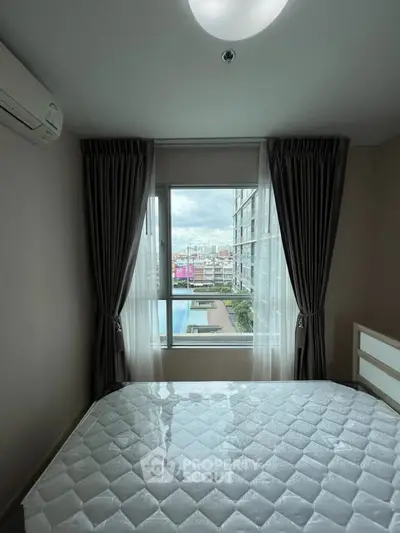 Cozy bedroom with a stunning city view, featuring a large window and modern furnishings.