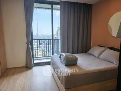 Modern bedroom with city view and balcony access in high-rise apartment.