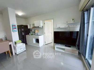 Modern living room with sleek kitchen and large TV, perfect for urban living.