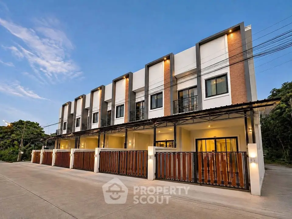 Modern townhouse exterior with sleek design and spacious balconies at sunset.