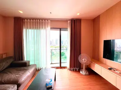 Spacious living room with modern decor and city view balcony, perfect for relaxation and entertainment.