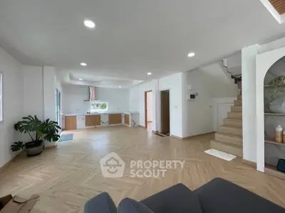 Spacious open-plan living room with modern kitchen and stylish staircase