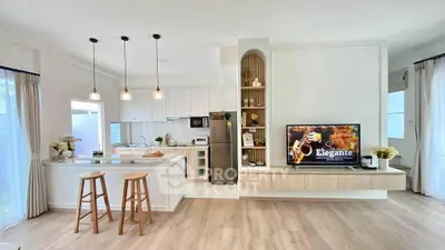 Modern open-layout kitchen and living room with stylish decor and natural light.