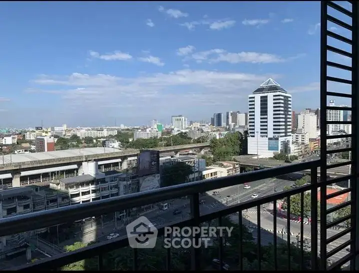 Stunning cityscape view from a high-rise balcony with clear blue skies.