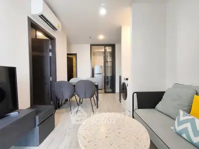 Modern living room with sleek furniture and open layout, featuring a cozy dining area and contemporary design.