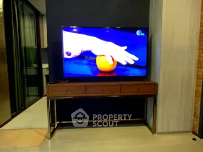 Modern living room with sleek TV stand and large flat-screen TV, perfect for entertainment.