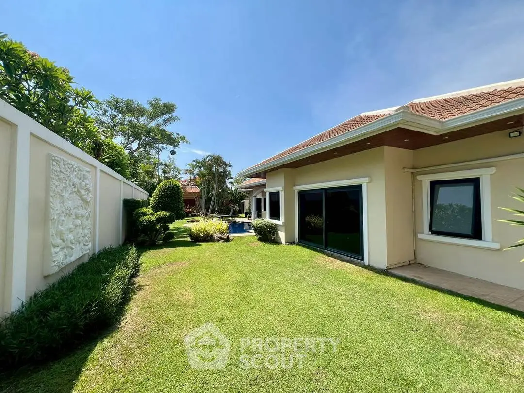 Charming single-story home with lush garden and spacious lawn, perfect for outdoor relaxation.