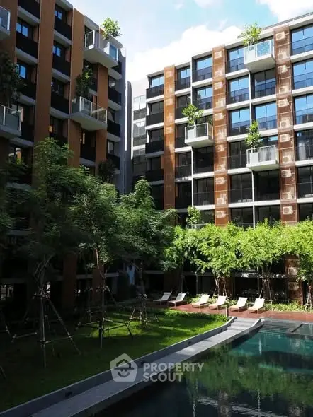 Modern apartment complex with lush garden and pool view