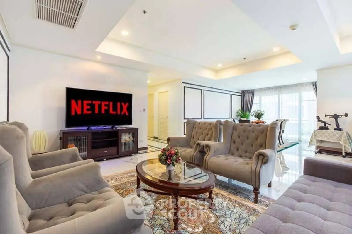 Luxurious living room with elegant furniture and large TV, perfect for entertainment.