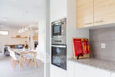 Modern open-plan kitchen and dining area with sleek appliances and stylish decor.