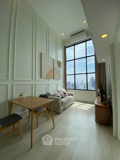 Stunning high-ceiling living room with city view, modern decor, and abundant natural light.